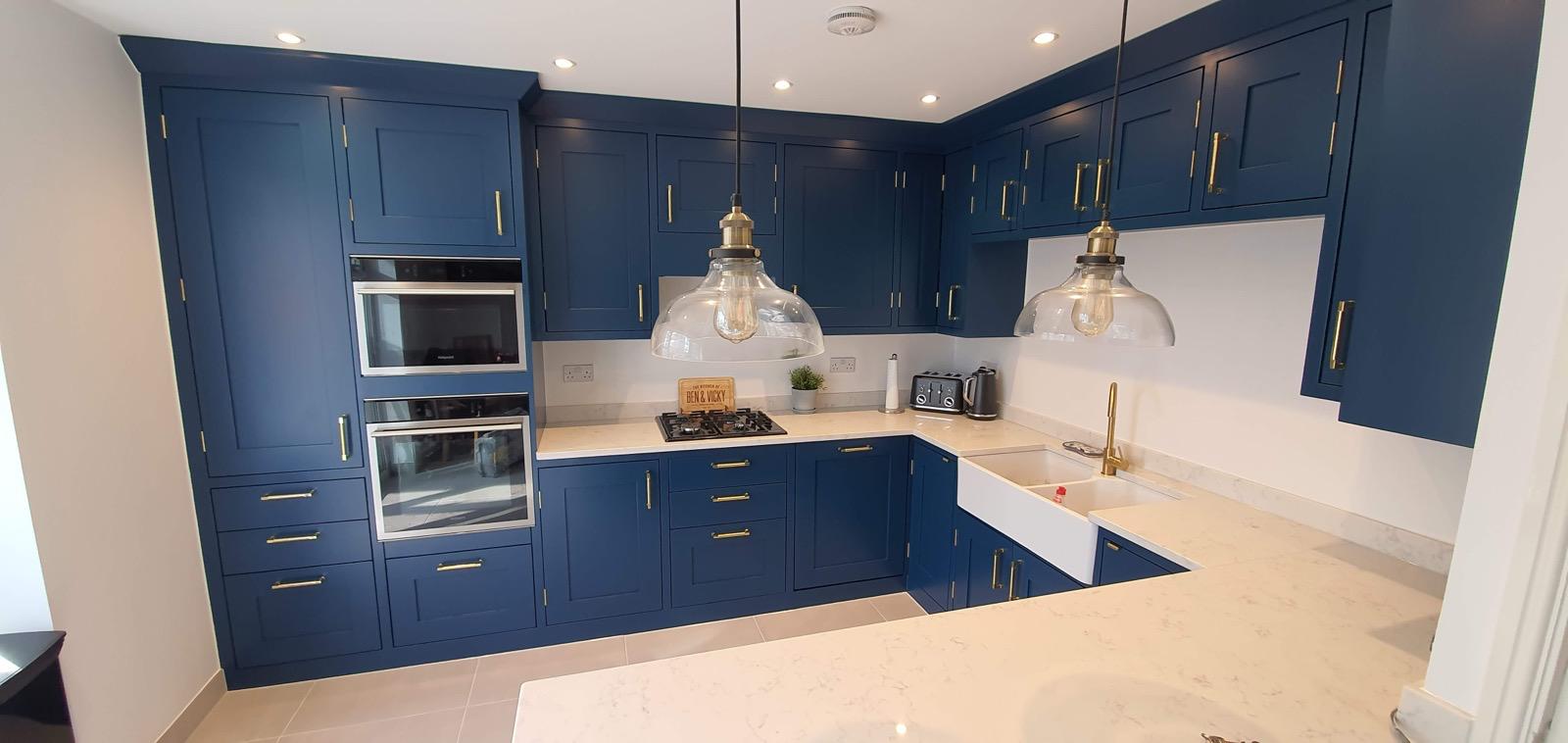 Blue kitchen with pendant lights and farmhouse sink