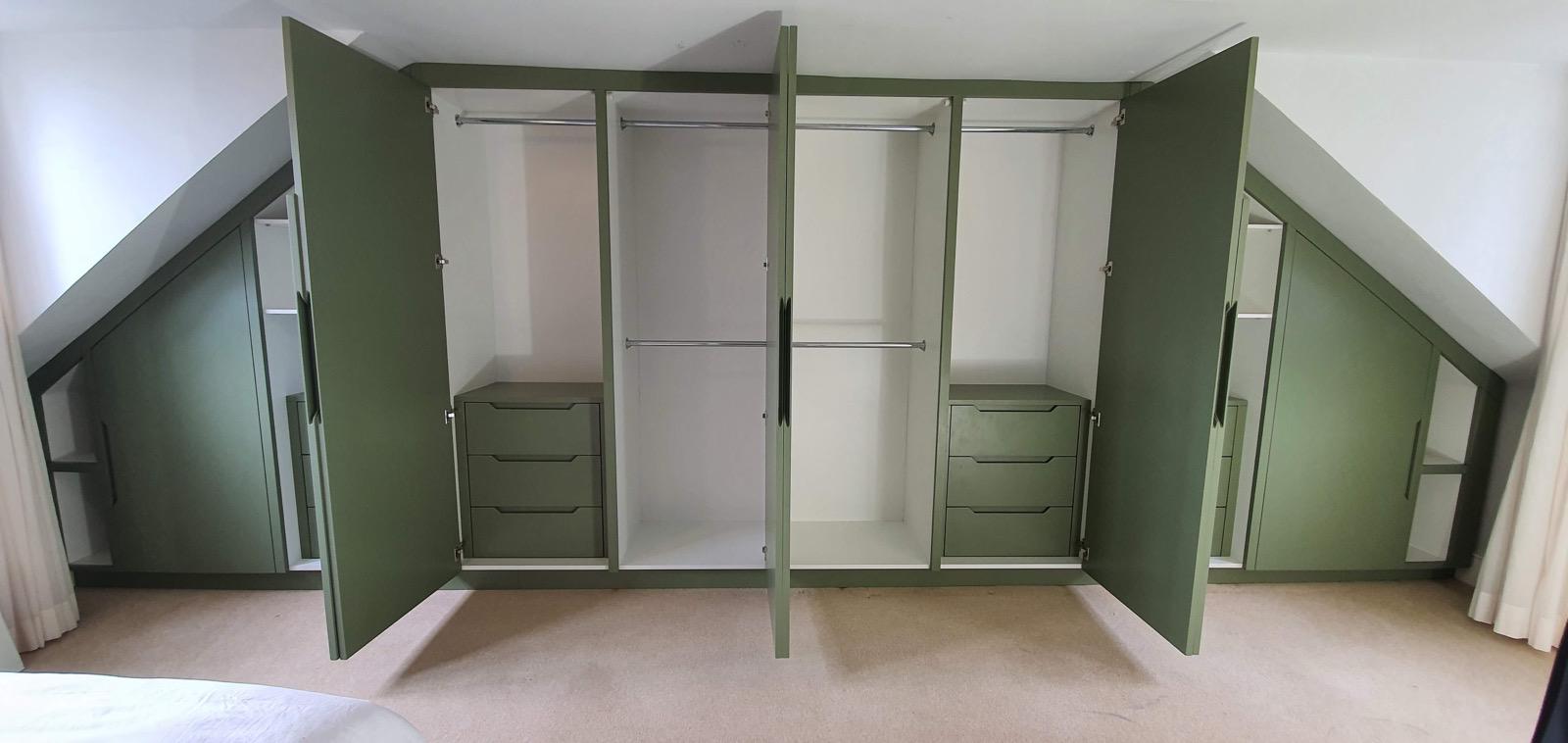 Sage green wardrobe interior with hanging rails and drawers