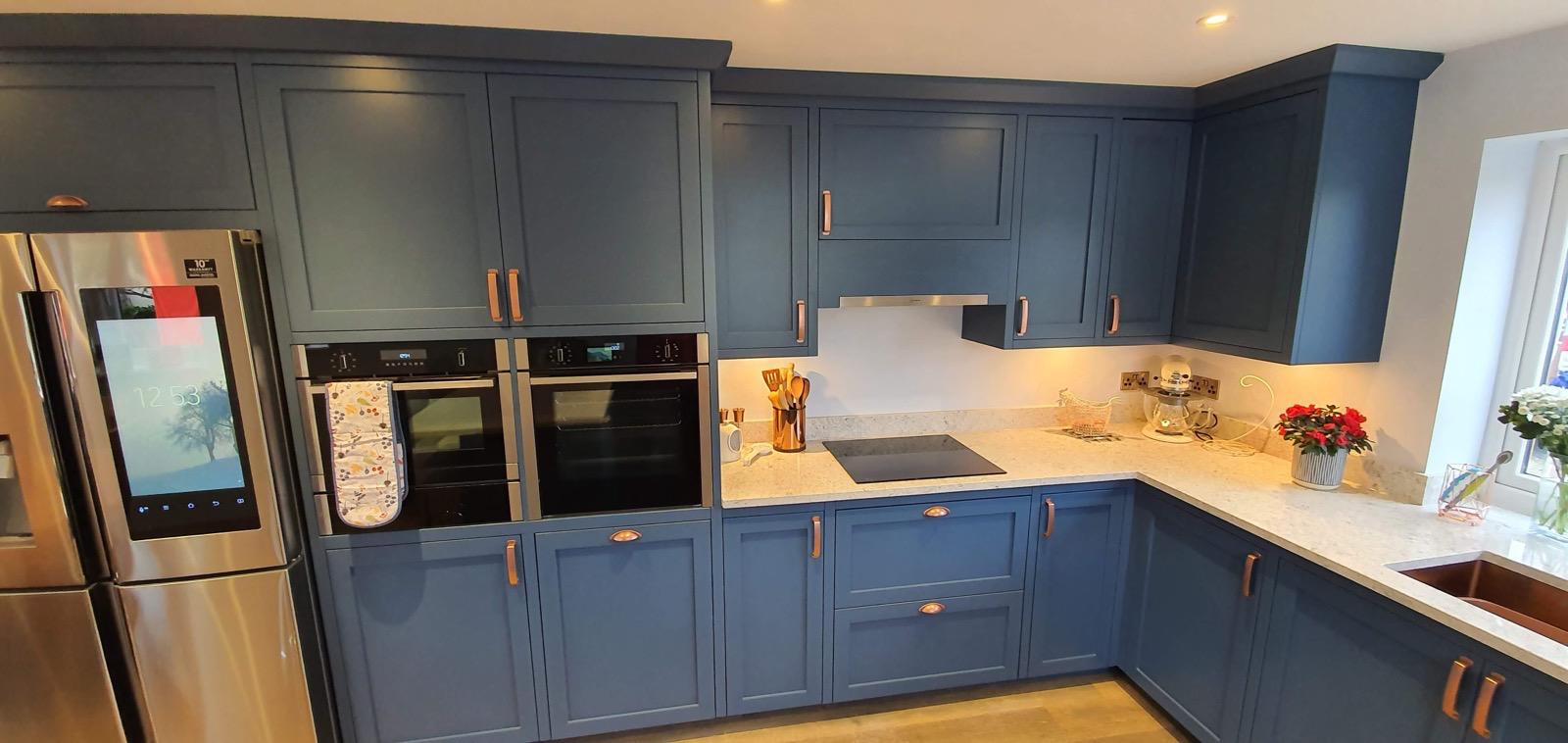 Blue kitchen with copper handles and double ovens
