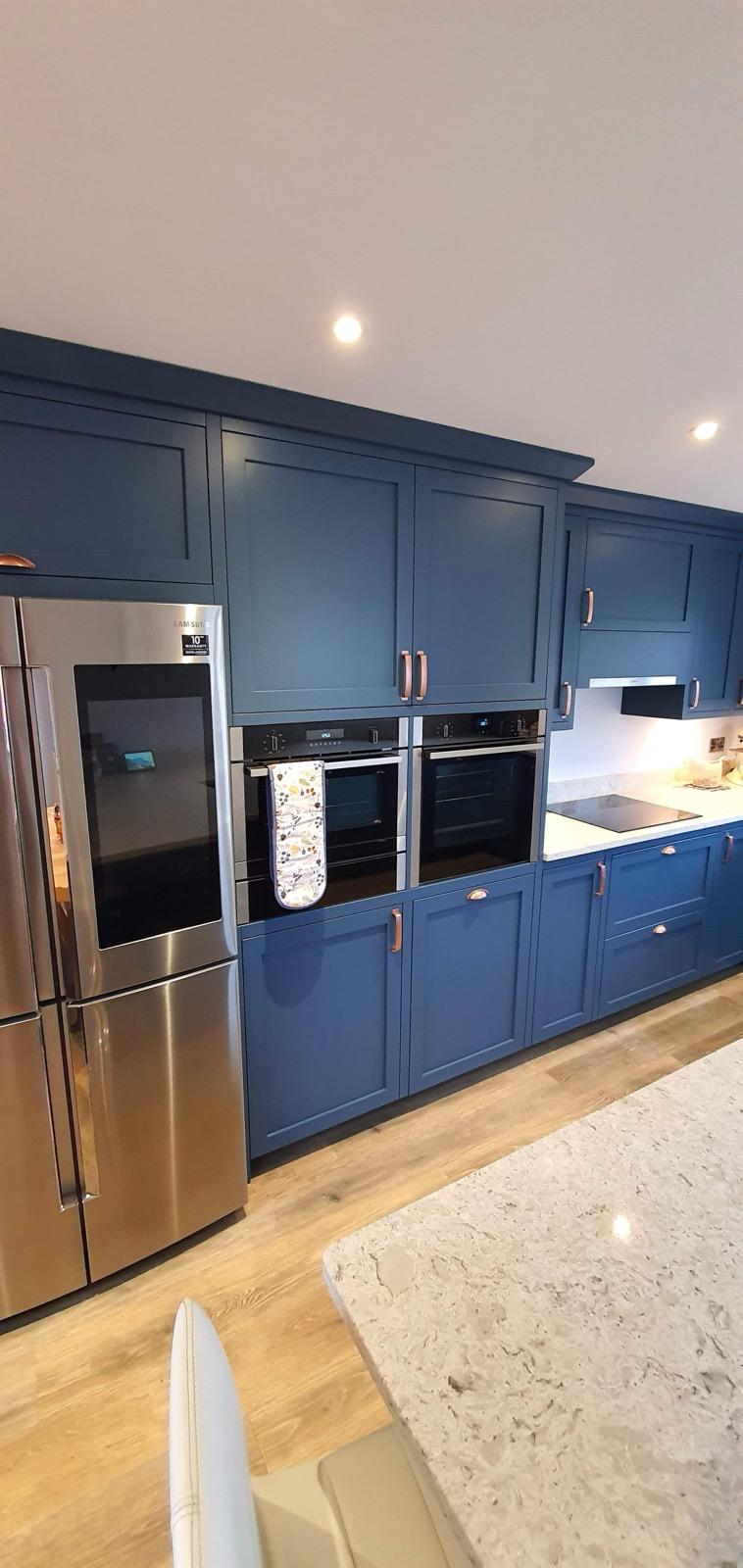 Blue kitchen with American fridge and double ovens